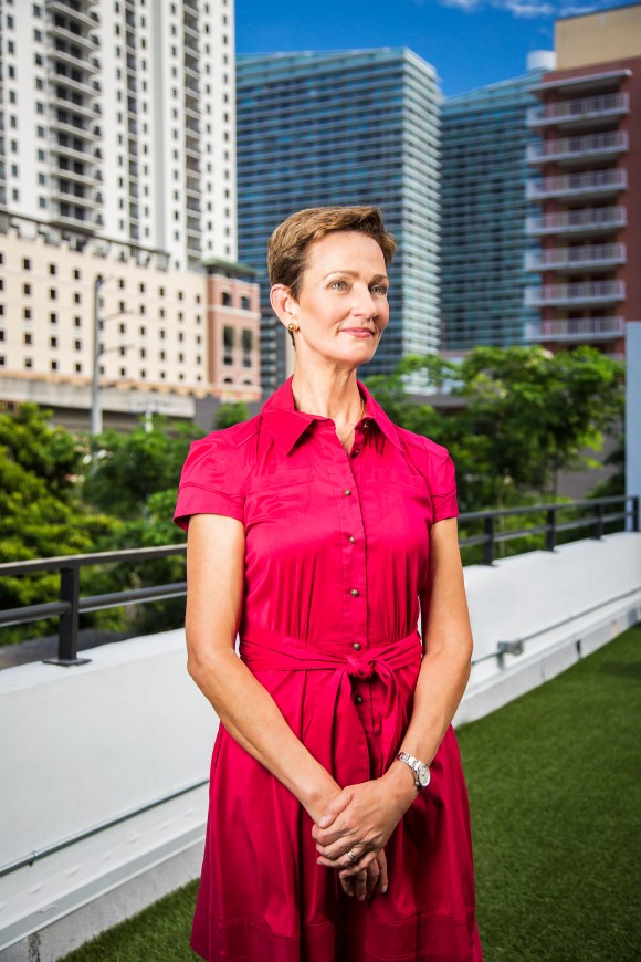 portrait photography of meg daly in pink dress standing on rooftop in front of brickell skyline