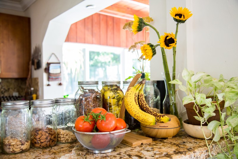 photograph-of-kitchen-counter-lined-with mason-jars-and-fresh-fruit