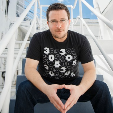 portrait photography of Billy Corben seated on staircase outside