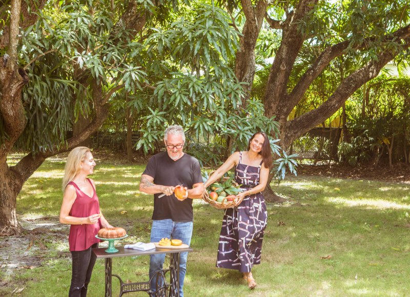photo of chef Michael Schwartz cutting up a mango, while chatting with food writer, Jen Karetnick and Geane Brito